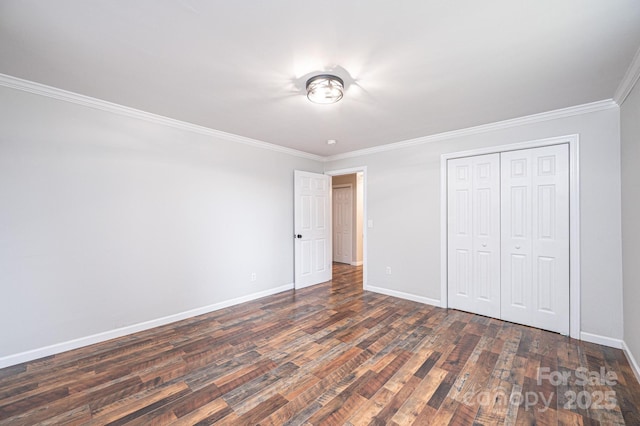 unfurnished bedroom featuring dark wood-style floors, a closet, baseboards, and ornamental molding