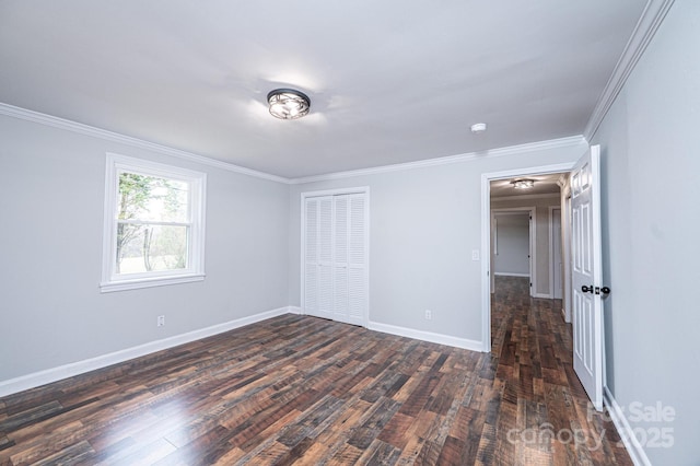 unfurnished bedroom featuring a closet, ornamental molding, baseboards, and dark wood-style flooring