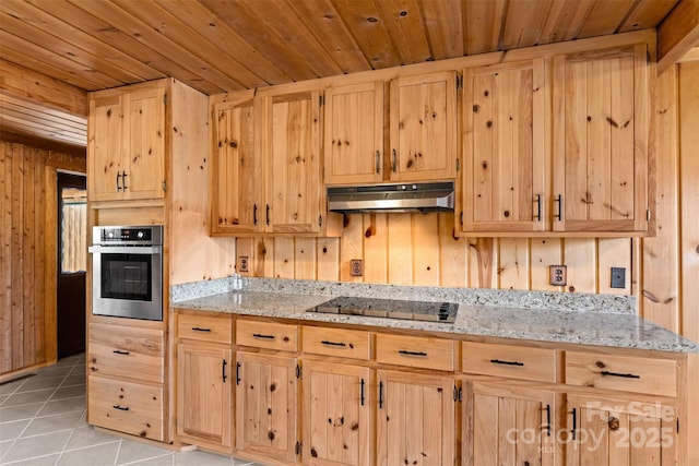 kitchen with black electric stovetop, light brown cabinetry, and oven