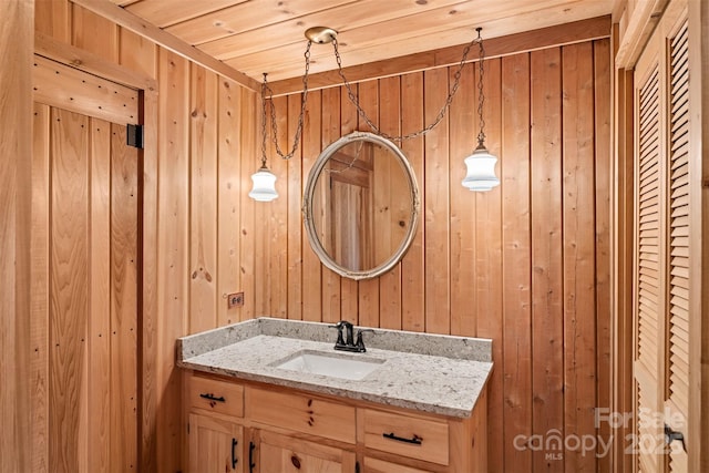 bathroom featuring vanity and wood walls