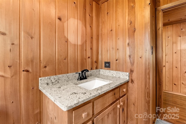 bathroom featuring wood walls and vanity