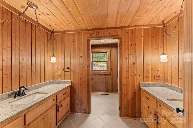 bathroom with tile patterned floors, wooden walls, wooden ceiling, and vanity