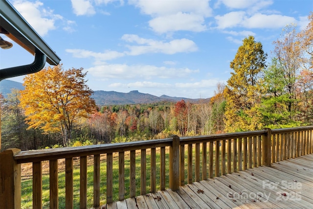 deck featuring a mountain view and a view of trees