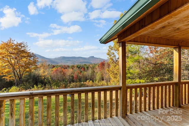 deck with a mountain view and a view of trees