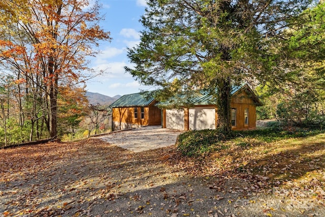 view of front of home with driveway and metal roof