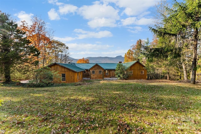 view of front of house with a standing seam roof, a front lawn, and metal roof