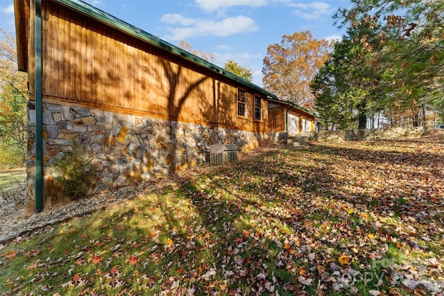 view of home's exterior featuring central air condition unit and stone siding