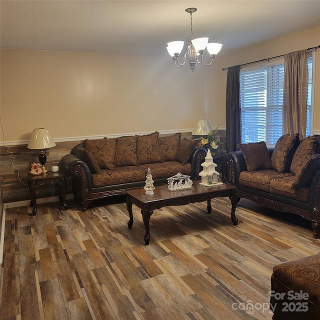 living room with hardwood / wood-style floors and an inviting chandelier