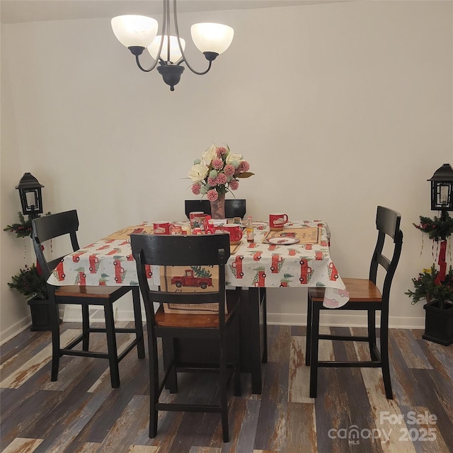 dining room with an inviting chandelier, baseboards, and wood finished floors