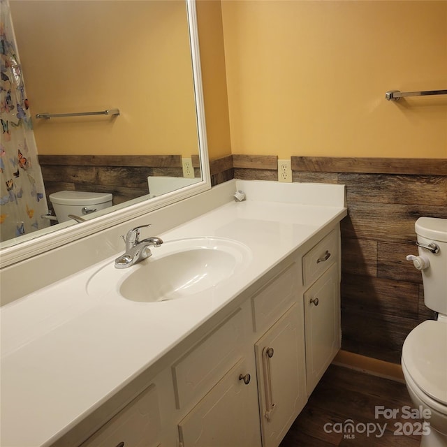 bathroom featuring a wainscoted wall, vanity, and toilet