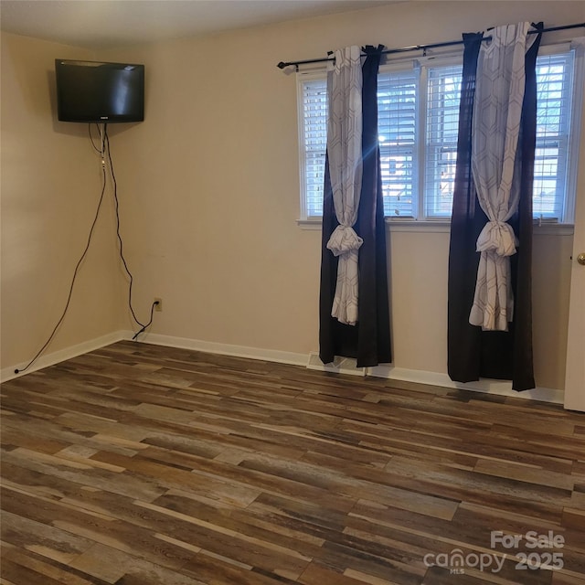 unfurnished room featuring dark wood finished floors and baseboards