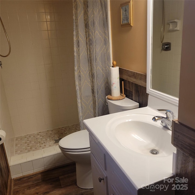 bathroom featuring vanity, wood finished floors, a shower stall, and toilet