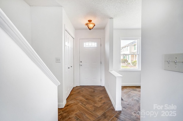 entrance foyer with baseboards and a textured ceiling