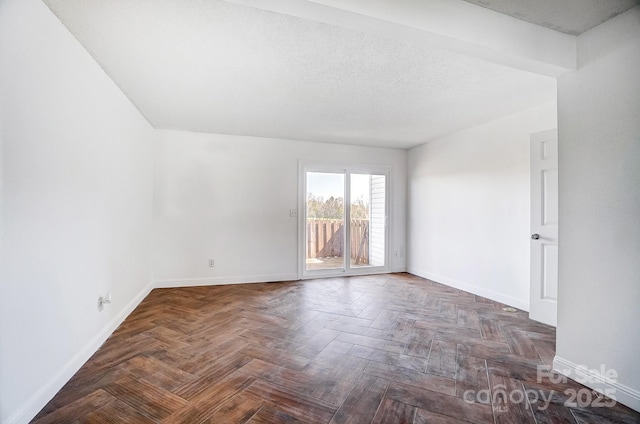 spare room with baseboards and a textured ceiling