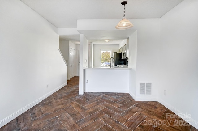 interior space featuring visible vents, baseboards, and a sink