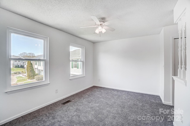 carpeted spare room featuring baseboards, visible vents, a textured ceiling, and ceiling fan