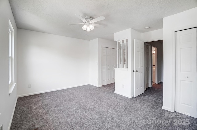 unfurnished bedroom featuring ceiling fan, baseboards, dark carpet, and a textured ceiling