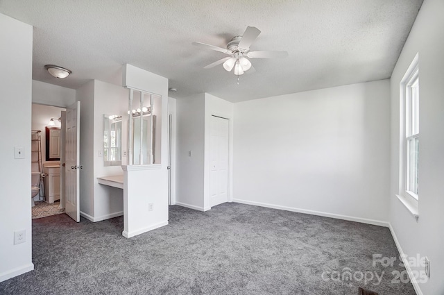 unfurnished bedroom with carpet, baseboards, and a textured ceiling