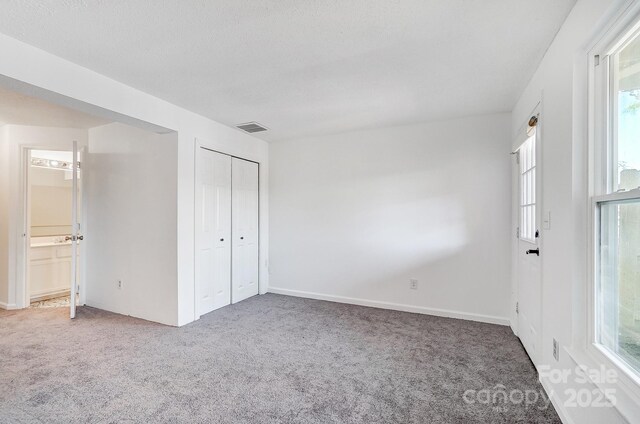 unfurnished bedroom with visible vents, baseboards, and carpet flooring