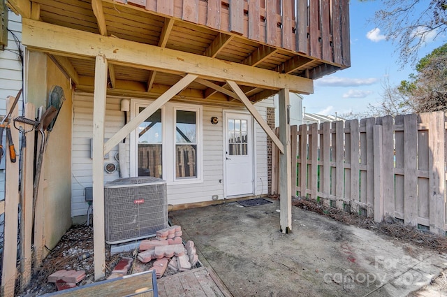 doorway to property with cooling unit, a patio area, and fence