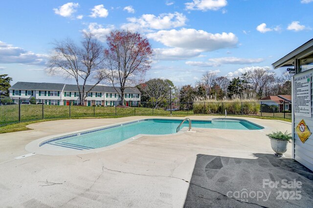 view of swimming pool featuring a patio, fence, and a fenced in pool