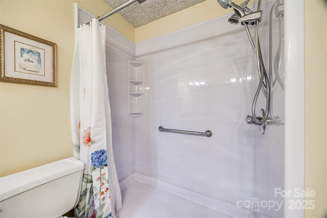 bathroom featuring toilet and a shower with curtain