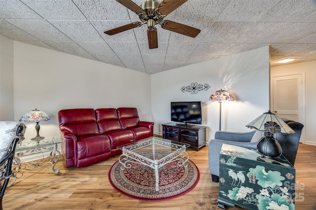 living area featuring ceiling fan, baseboards, and wood finished floors