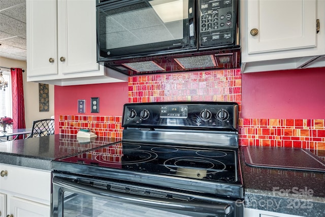 kitchen with tasteful backsplash, white cabinets, black appliances, and dark countertops