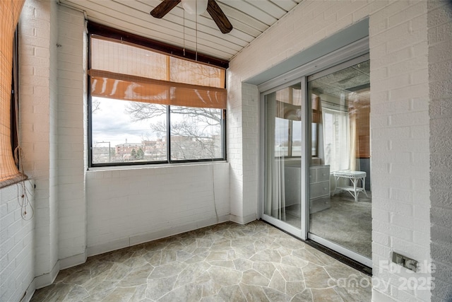 unfurnished sunroom featuring ceiling fan