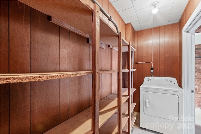 washroom with washer / dryer, wood walls, and laundry area