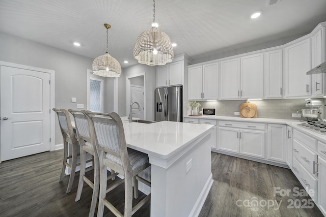 kitchen with dark wood-style flooring, white cabinets, appliances with stainless steel finishes, and a sink