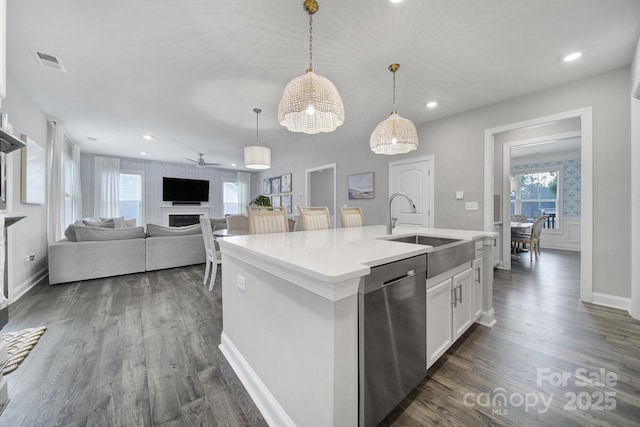 kitchen with a center island with sink, visible vents, ceiling fan, a sink, and dishwasher