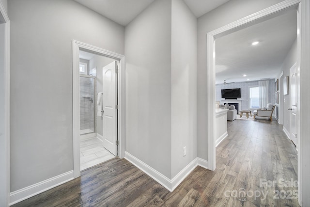 corridor with recessed lighting, baseboards, and dark wood-style flooring