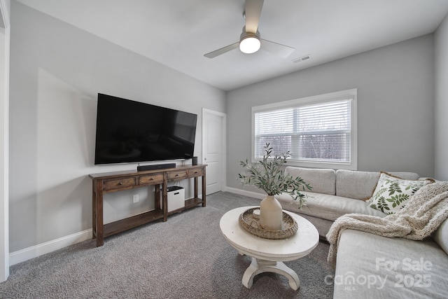 carpeted living room featuring visible vents, baseboards, and a ceiling fan