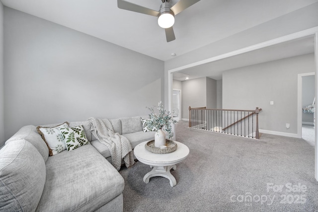 living area featuring carpet flooring, baseboards, and ceiling fan