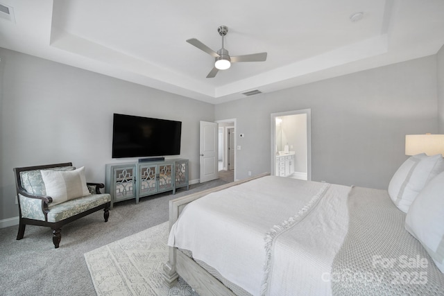 carpeted bedroom with a ceiling fan, a raised ceiling, baseboards, and visible vents