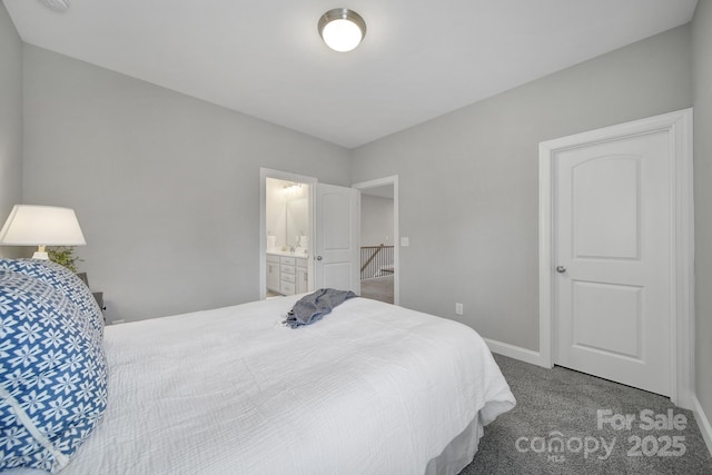 bedroom featuring baseboards, ensuite bathroom, and carpet