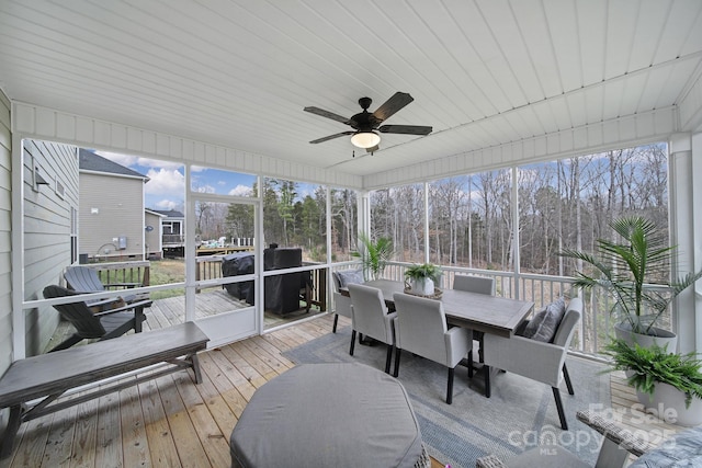 sunroom / solarium featuring plenty of natural light and a ceiling fan