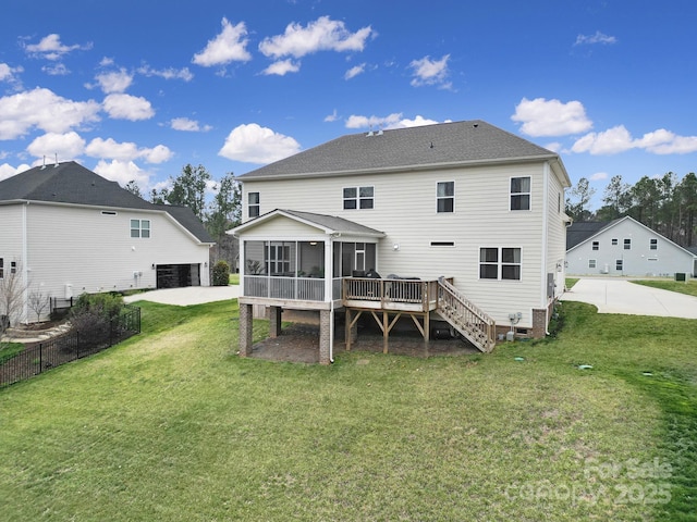 rear view of property featuring fence, a yard, roof with shingles, a sunroom, and stairs