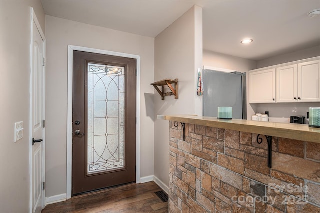 entryway featuring baseboards and dark wood-style flooring