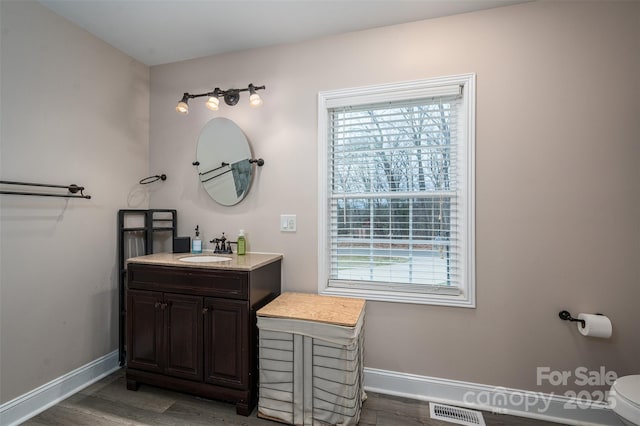 bathroom with visible vents, baseboards, and wood finished floors