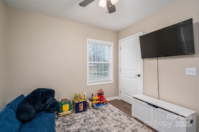 rec room featuring a ceiling fan, dark wood-style flooring, and baseboards