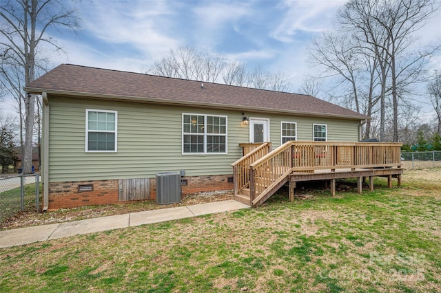 rear view of property featuring fence, a wooden deck, central AC unit, a lawn, and crawl space