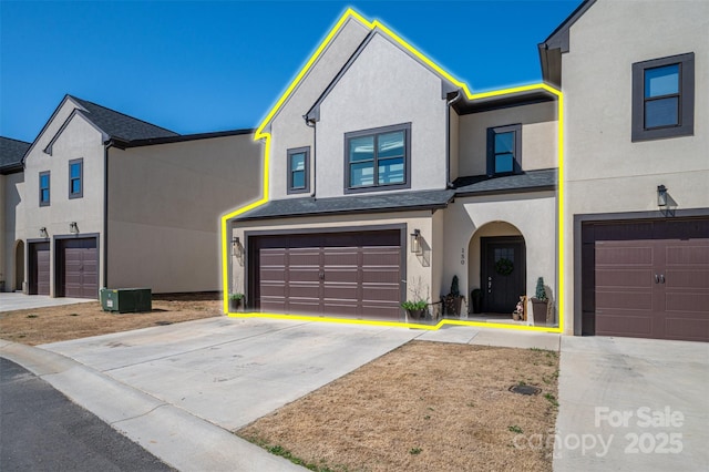 view of front of property featuring stucco siding, an attached garage, and concrete driveway