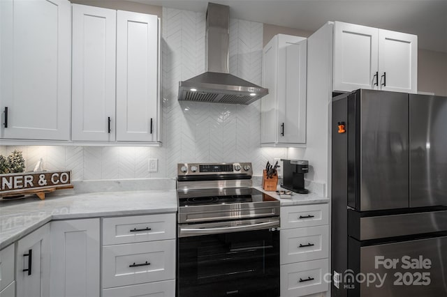 kitchen featuring stainless steel appliances, tasteful backsplash, wall chimney exhaust hood, and white cabinetry