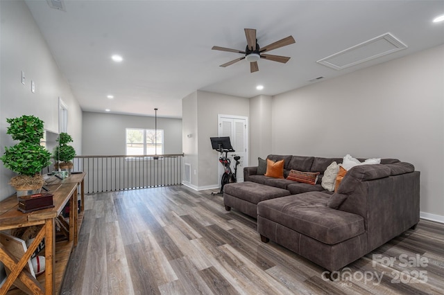 living room featuring wood finished floors, a ceiling fan, and baseboards