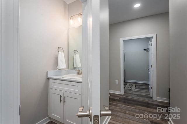 bathroom featuring vanity, baseboards, and wood finished floors