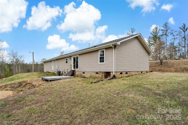 rear view of house featuring crawl space, a lawn, and entry steps