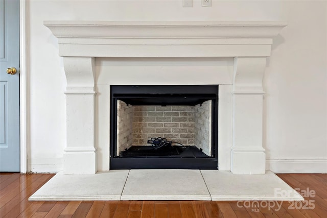 interior details featuring wood finished floors and a fireplace