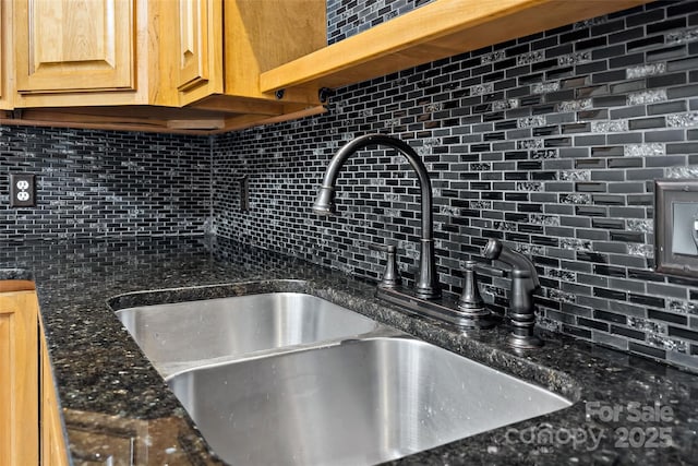 interior details featuring a sink and backsplash